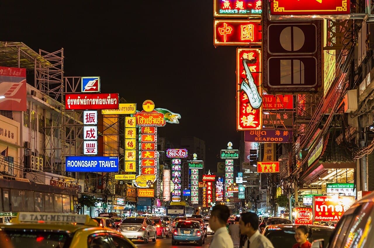 Neon signs above the traffic on Yaowarat Road, Bangkok's Chinatown